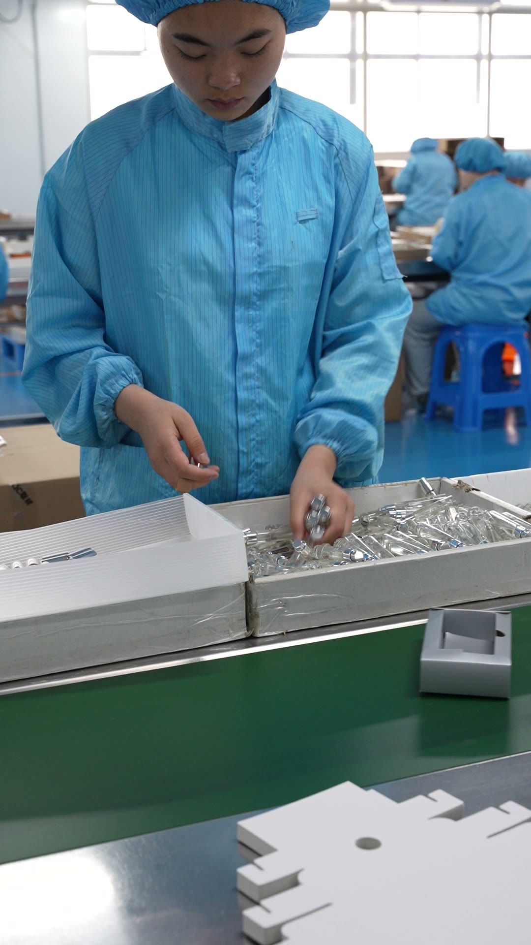 Worker assembling perfume gift sets on the packing line
