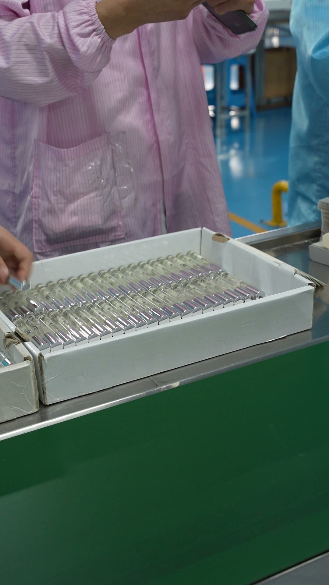 Filled perfume bottles in trays on the line